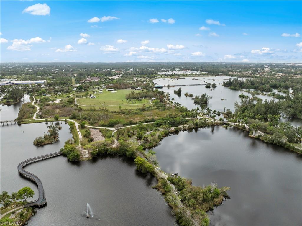 Aerial view of the surrounding area featuring several bodies of water, lush green trees, and walking paths