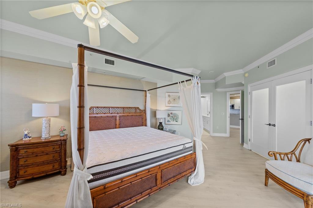 This bedroom features light-colored flooring and crown molding