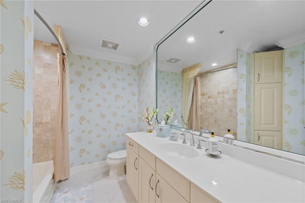 Bathroom featuring a spacious vanity with an integrated sink, a large mirror, and recessed lighting