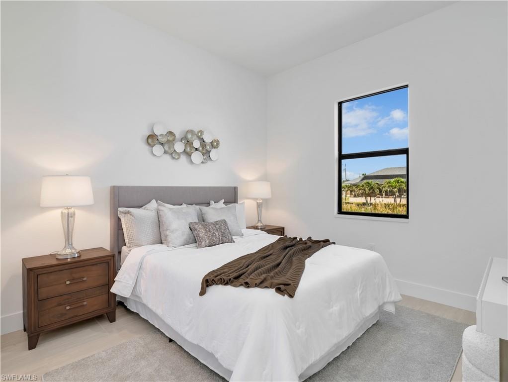 Bright bedroom featuring light wood-finish flooring and a single rectangular window  photos used from another listing to show what it would look like with furniture