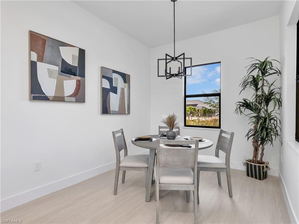 Dining area featuring light wood-finish flooring and a contemporary black geometric chandelier photos used from another listing to show what it would look like with furniture