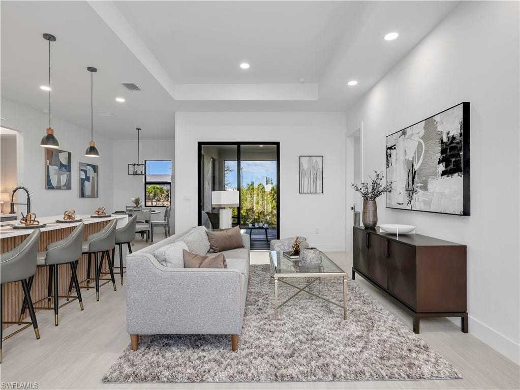 Open-concept living space featuring wood-finish flooring, recessed lighting, and a kitchen island with pendant lighting - photos used from another listing to show what it would look like with furniture