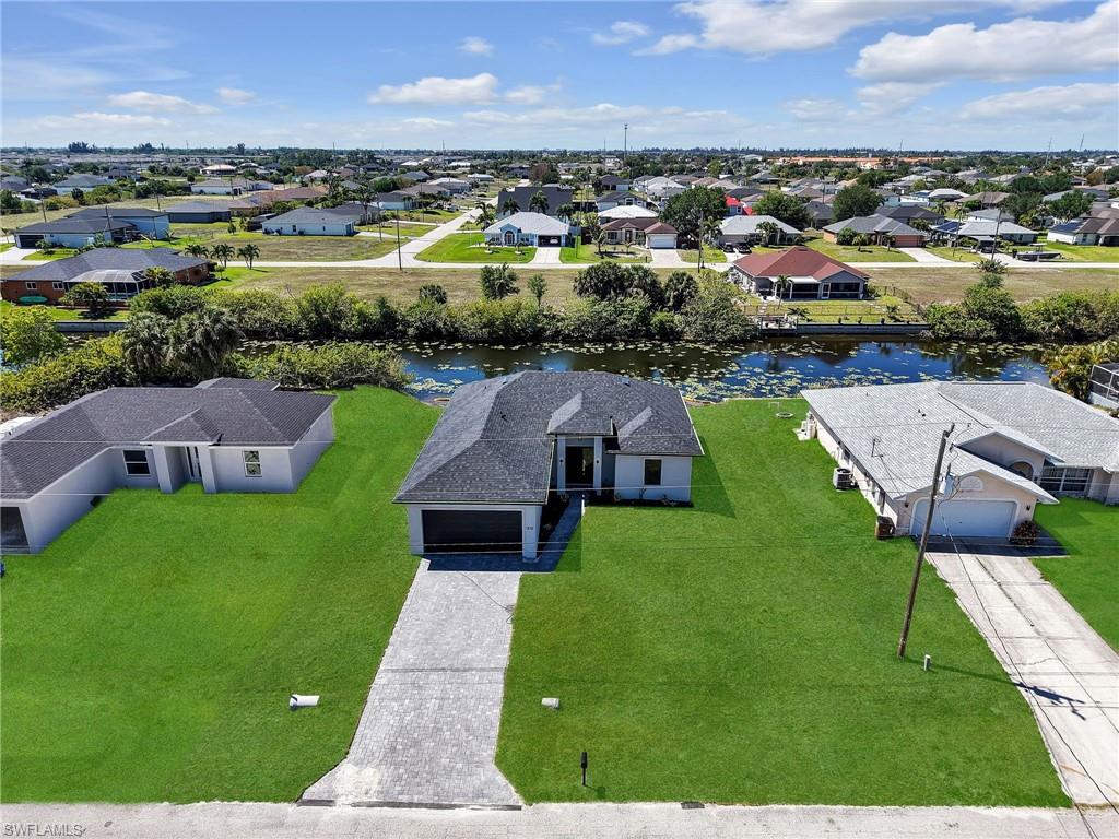 Contemporary-style home featuring a dark shingle roof and a light-colored exterior  the color of the grass has been virtually enhanced