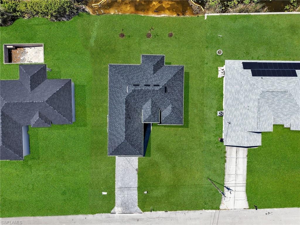 Newly sodded lawn surrounding a dark shingle roofline  the color of the grass has been virtually enhanced