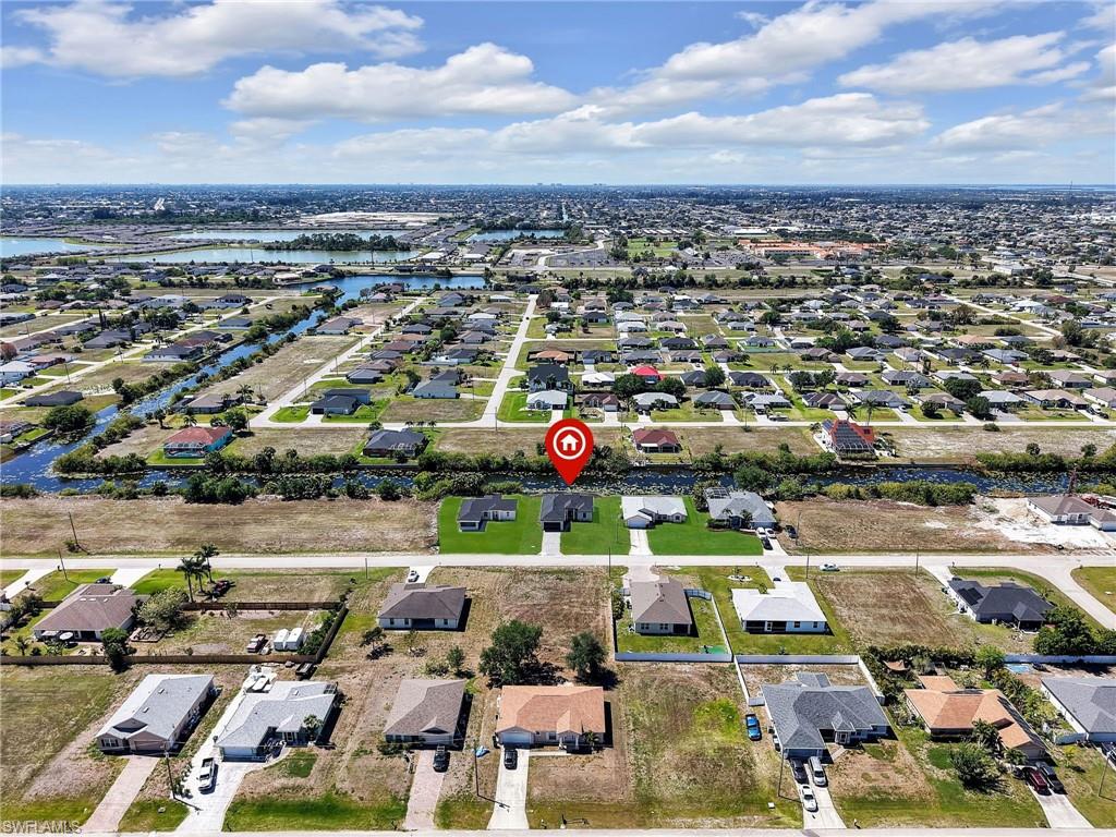 Aerial perspective showcasing a residential neighborhood with numerous single-story homes, many featuring paved driveways and green lawns  the color of the grass has been virtually enhanced