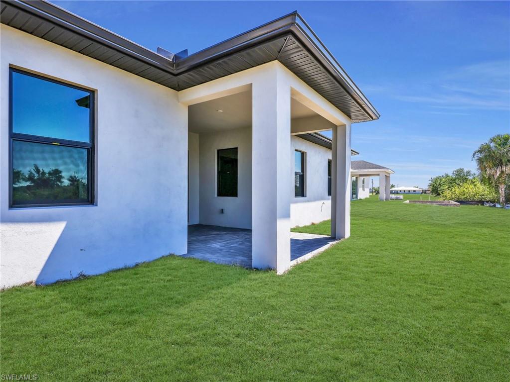 Back of house showing covered patio - the grass color has been virtually enhanced