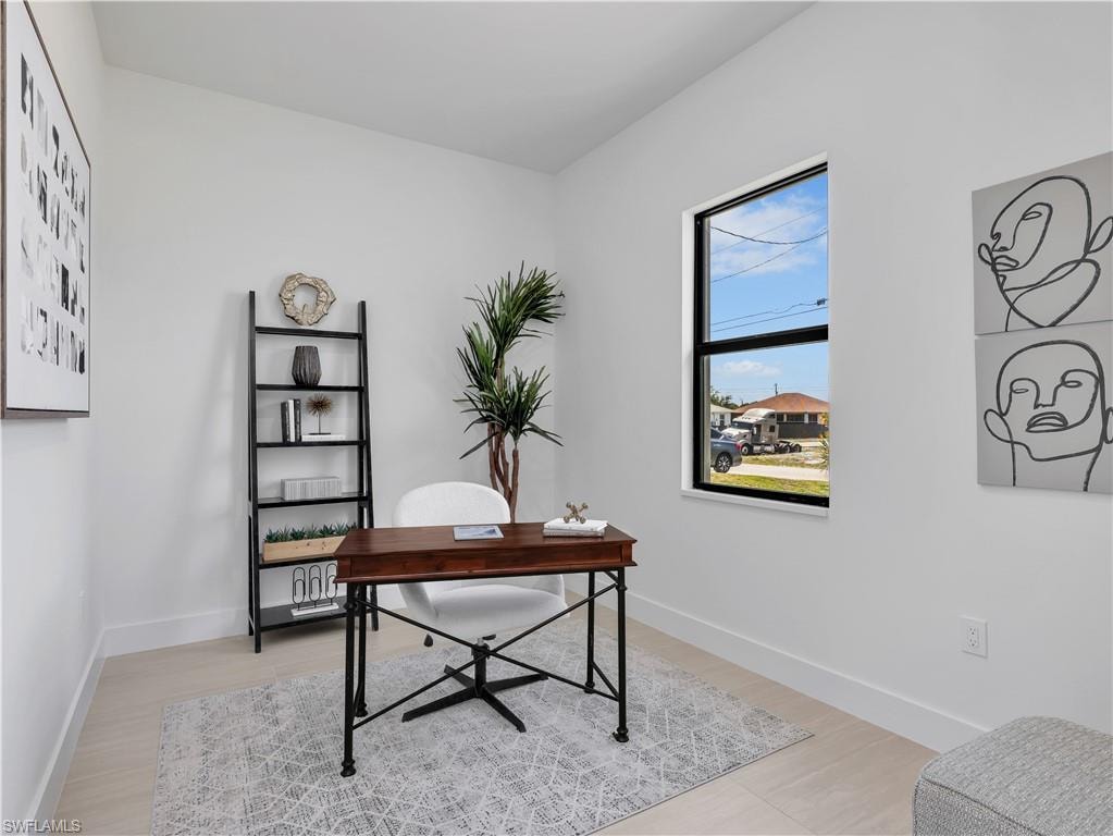 Bright room featuring a single window with black trim, light-toned flooring, and white baseboards  photos used from another listing to show what it would look like with furniture