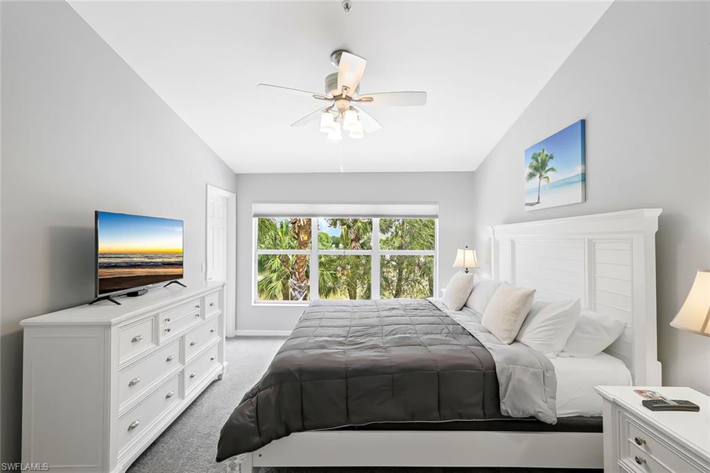 Carpeted bedroom featuring lofted ceiling and ceiling fan