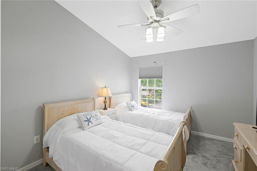 Bedroom with carpet, ceiling fan, and vaulted ceiling