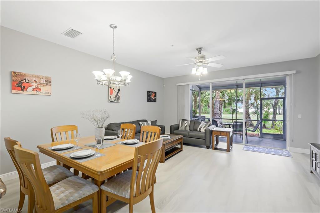 Dining space featuring ceiling fan with notable chandelier and light hardwood / wood-style flooring
