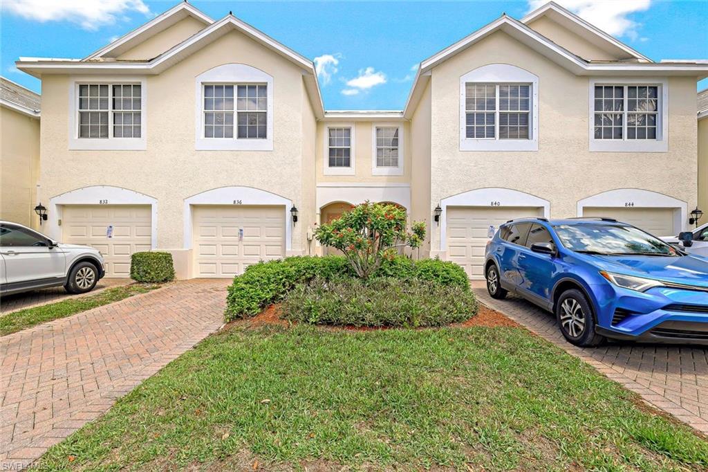 Townhome / multi-family property with a garage and a front yard