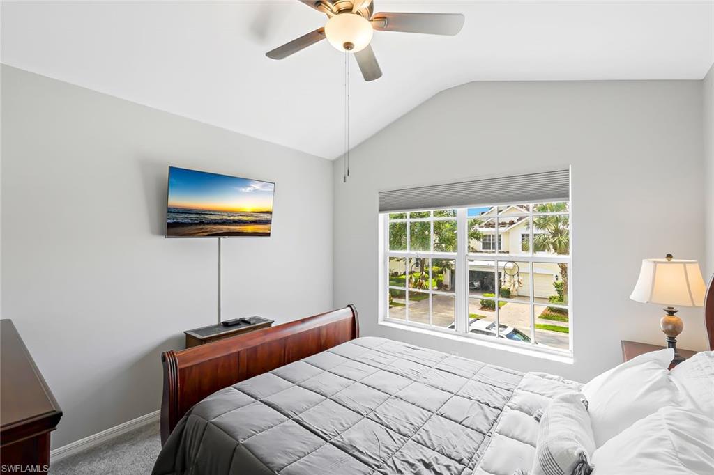 Bedroom with carpet flooring, ceiling fan, and lofted ceiling