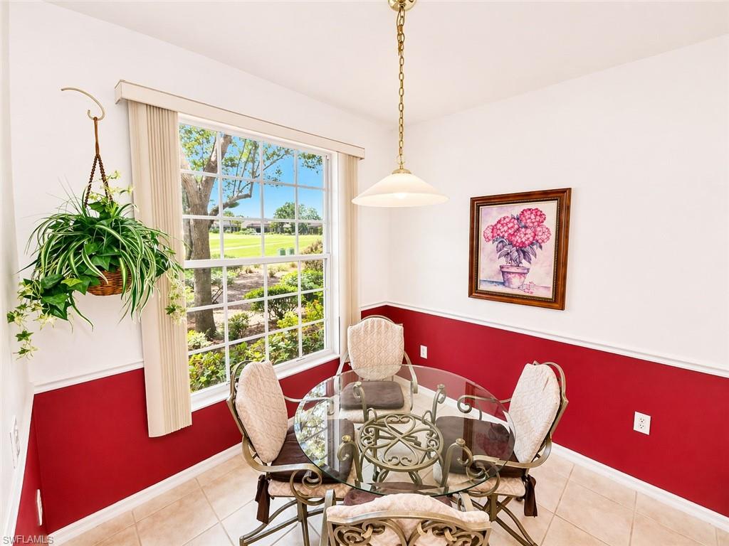 Sunny breakfast nook surrounded by windows overlooking lush landscaping.