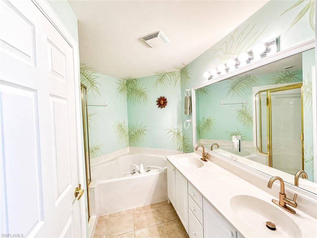 Primary bath with dual vanities, soaking tub, and separate walk-in shower.