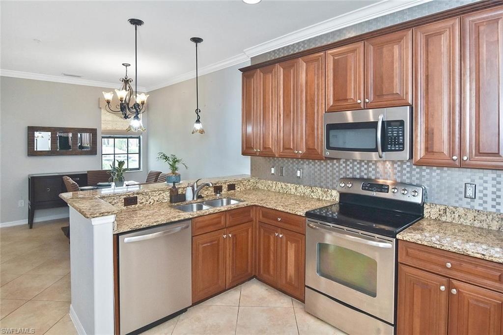 Rich pecan-colored cabinetry is accented by a unique metal backsplash and stainless appliances.