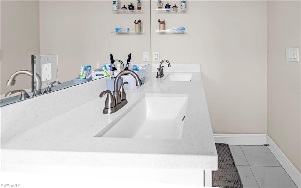Double vanity featuring integrated rectangular sinks, white stone-finish countertop, and brushed nickel faucets