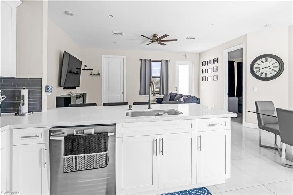 Contemporary kitchen island featuring a stainless steel sink, gooseneck faucet, and integrated dishwasher