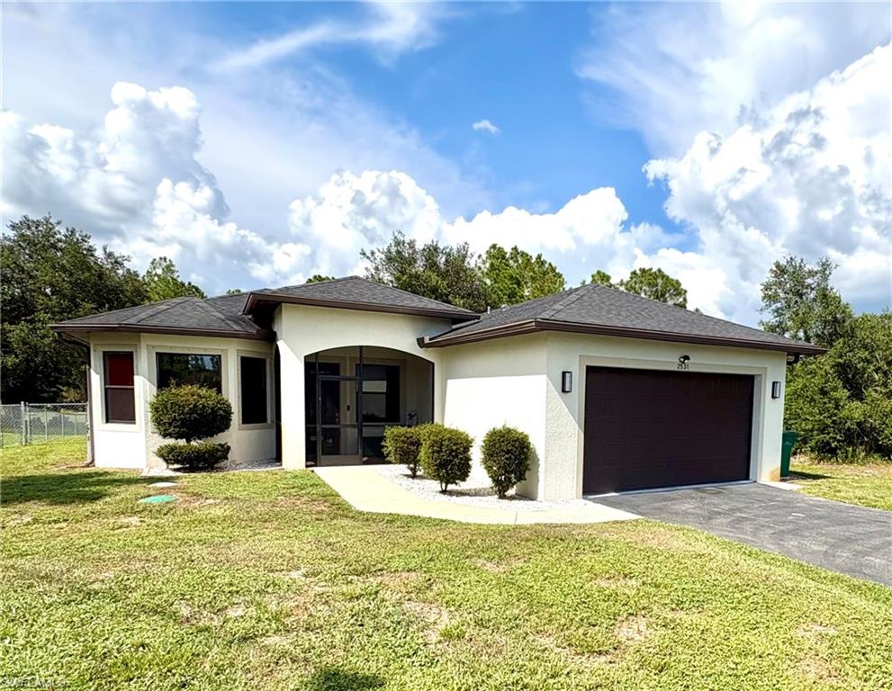 Contemporary stucco exterior featuring an arched screened entry, dark shingle roof, and an attached garage with a dark panel door