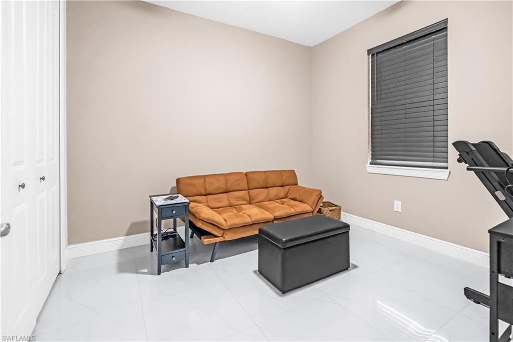 Bedroom #3 and or den with Neutral-toned walls complement the white baseboards and large format white tile flooring