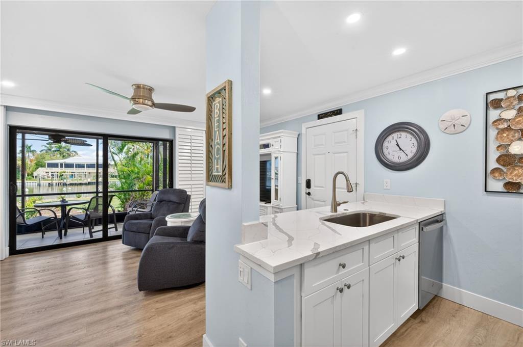 Kitchen featuring white cabinetry, a stainless steel sink, and a light-toned countertop