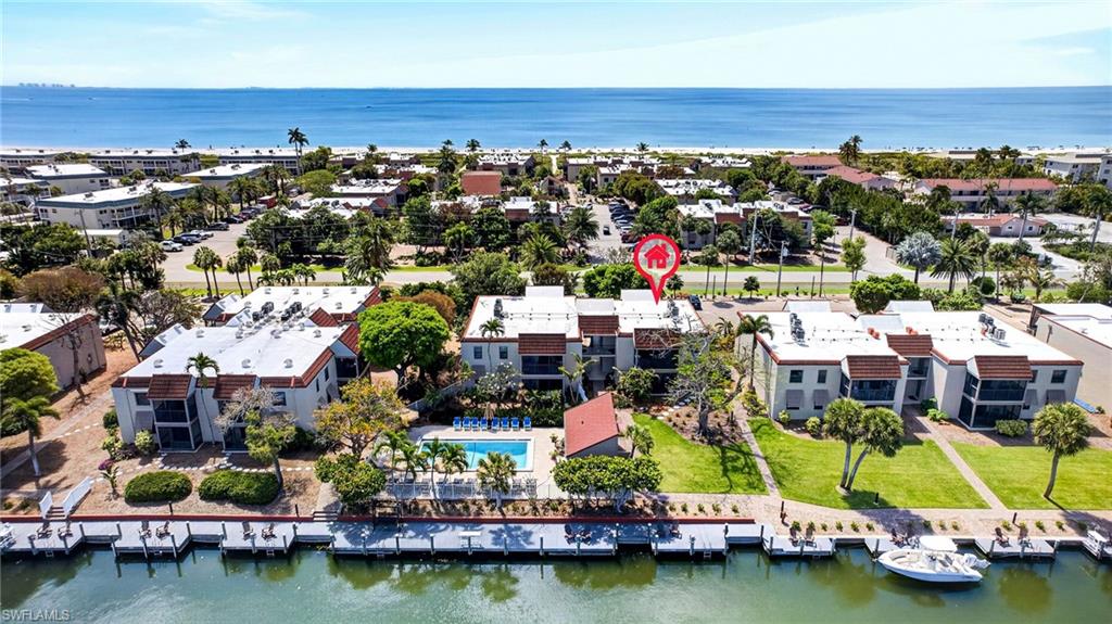 Waterfront condominium complex featuring a dock, swimming pool, and proximity to the Gulf of Mexico