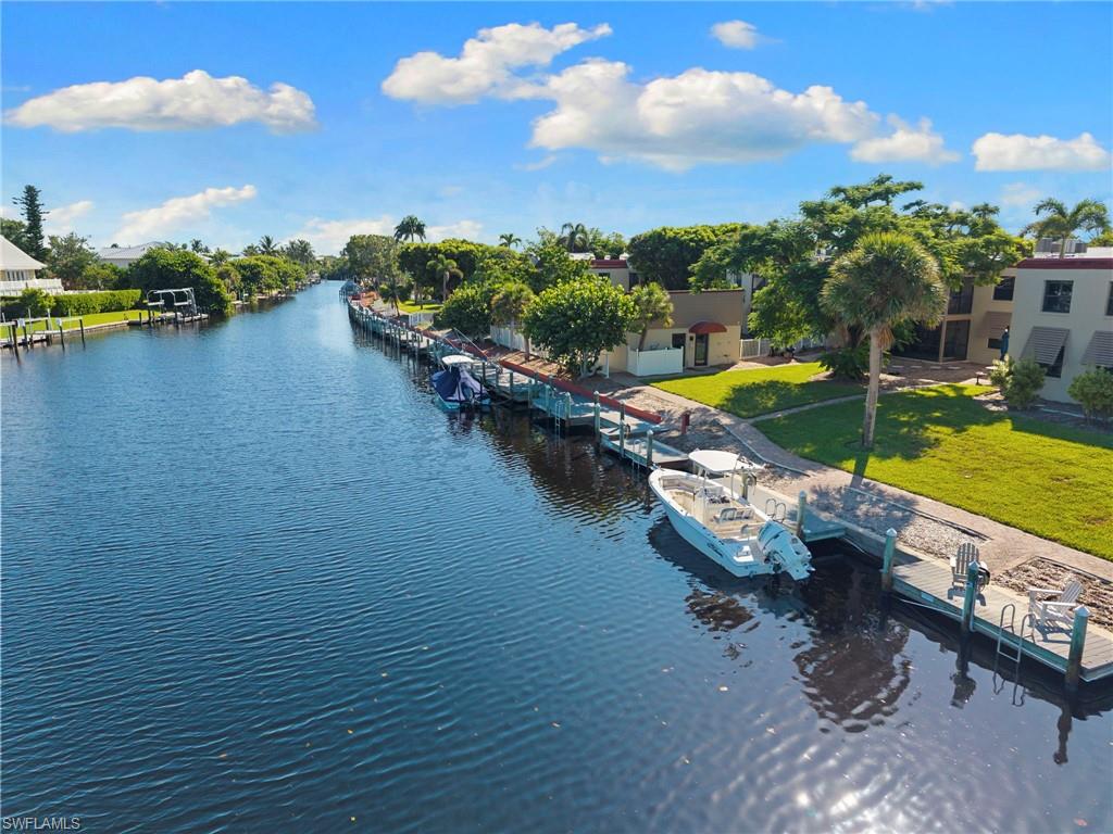 Waterfront property featuring a private boat dock, concrete seawall, and direct canal access