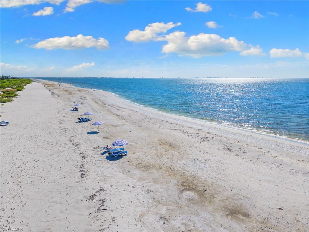 Expansive sandy beach bordering a sparkling blue ocean under a clear sky
