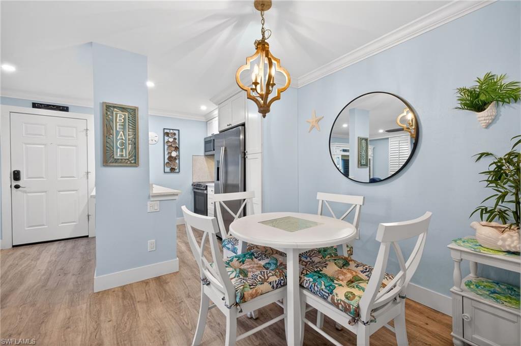 Dining area featuring wood-finish flooring, light blue walls, and a decorative ceiling light fixture