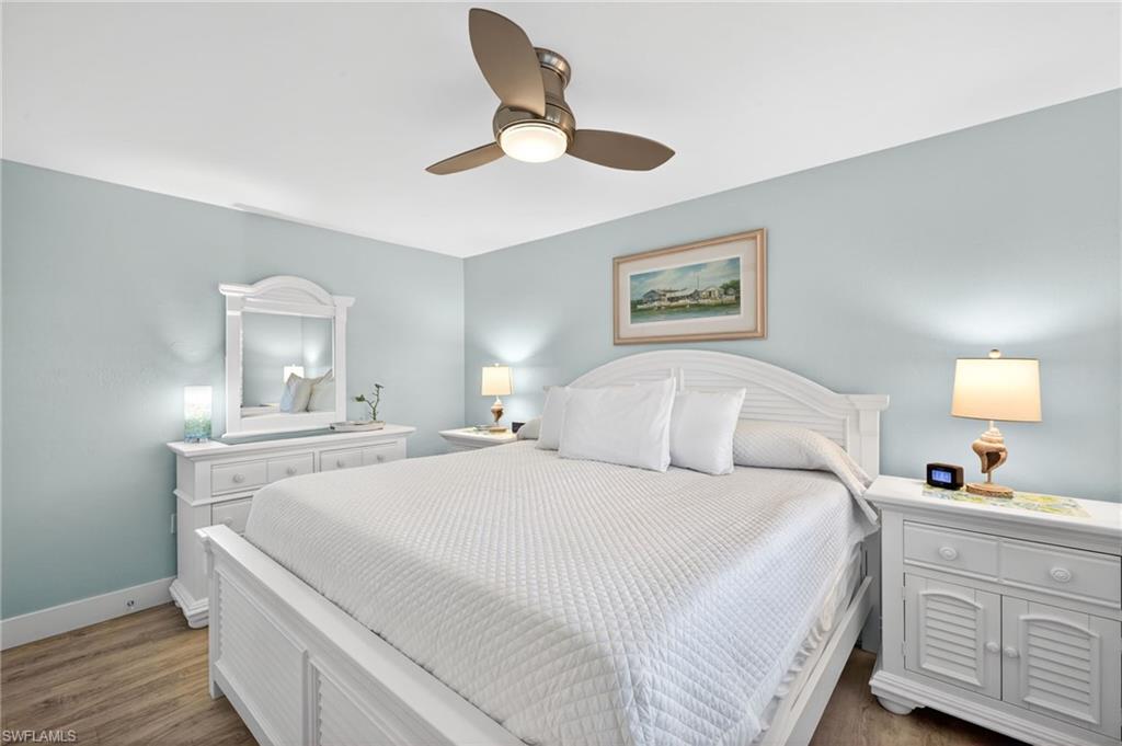Spacious bedroom with light blue walls and wood-finish flooring