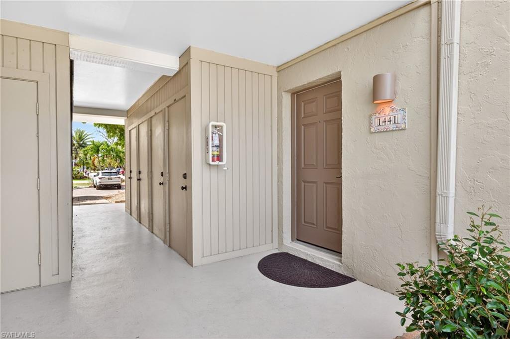 Covered entryway featuring a paneled door, stucco exterior, and a wall-mounted light fixture