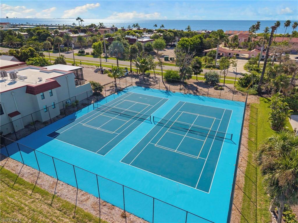 Two regulation tennis courts with blue surfacing and white line markings, surrounded by black fencing