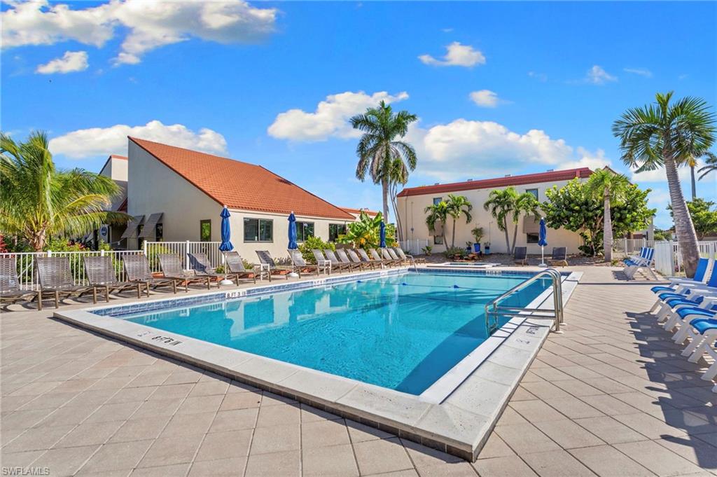 Rectangular swimming pool surrounded by a large paver deck
