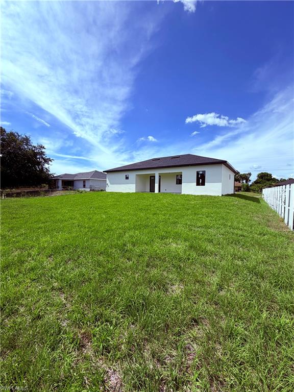Expansive grassy yard with a white picket fence on one side