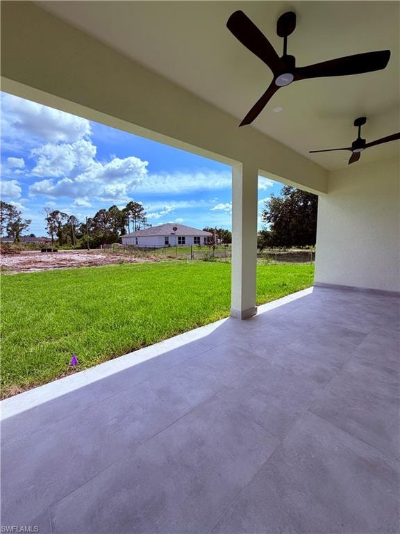 Spacious covered patio with large format tile flooring and dual ceiling fans