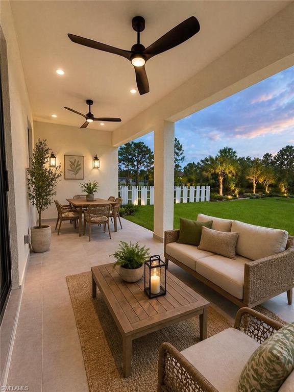 Spacious covered patio featuring recessed lighting, dual ceiling fans, and a tiled surface