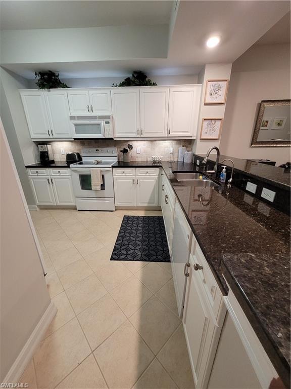 Kitchen with sink, white cabinets, backsplash, and range
