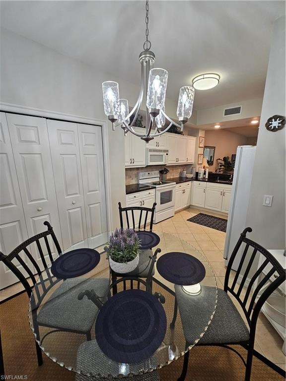 Dining space with a chandelier and light tile patterned flooring