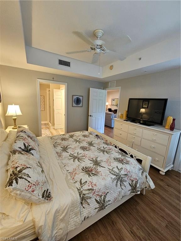 Bedroom featuring wood finished floors, ceiling fan, and connected bathroom