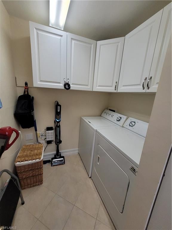 Laundry room featuring hookup for a washing machine, separate washer and dryer, cabinets, and light tile floors
