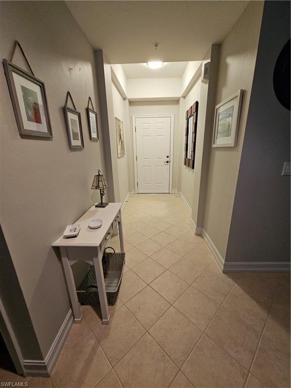 Corridor with light tile patterned floors and baseboards