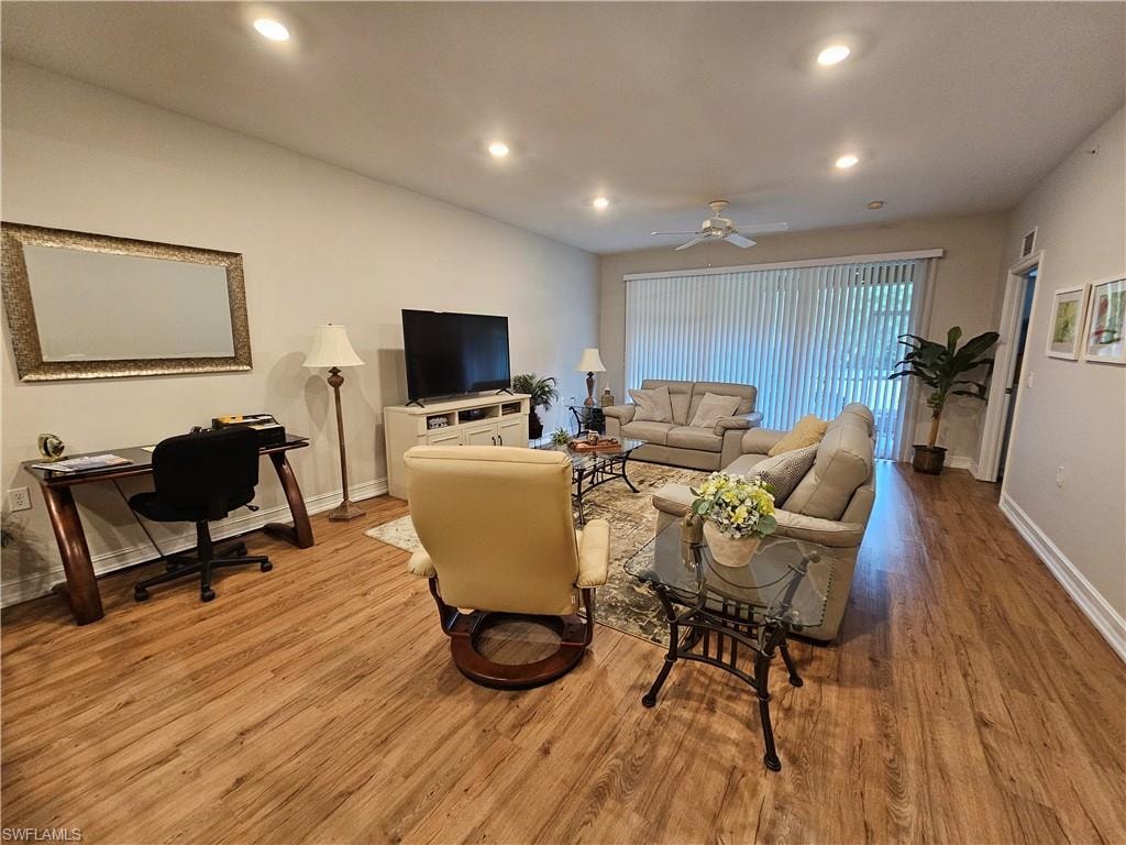 Living area featuring wood finished floors, recessed lighting, ceiling fan, and a desk