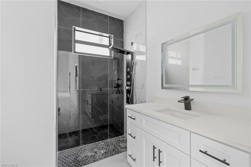 Bathroom with a shower with door and vanity