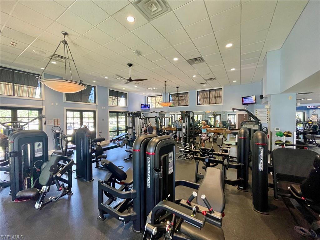 Spacious fitness center featuring high ceilings, recessed lighting, and multiple exercise machines