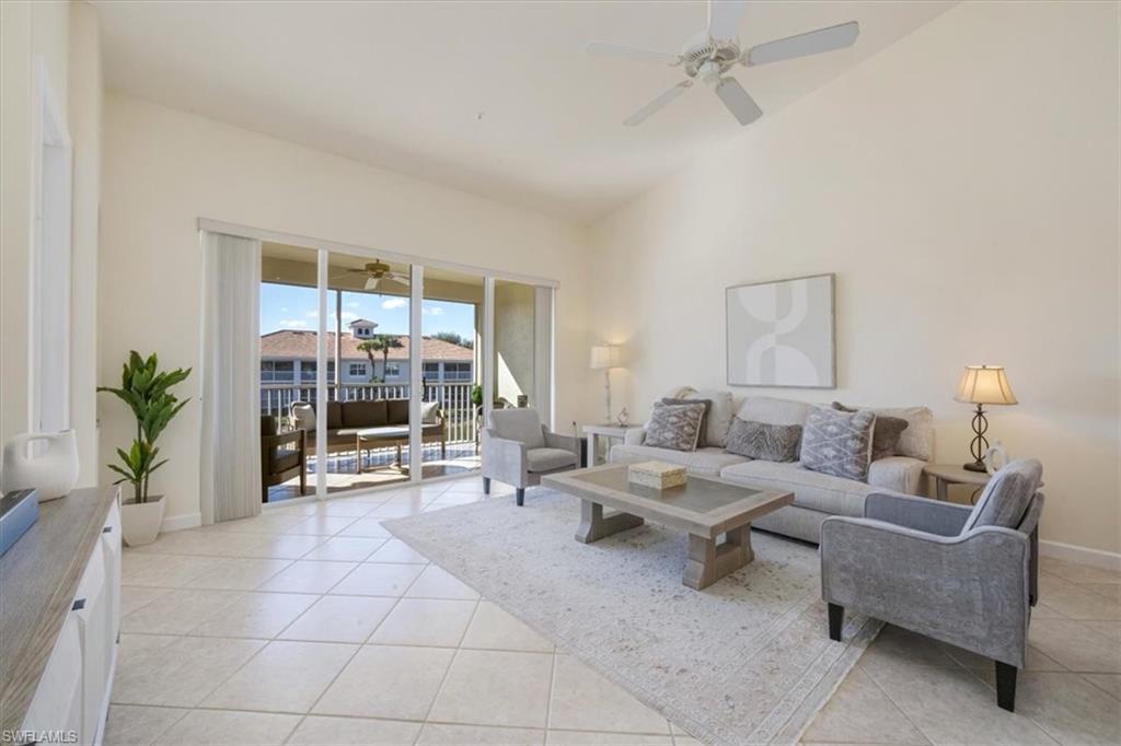 Living area with light tile patterned flooring, high vaulted ceiling, and ceiling fan