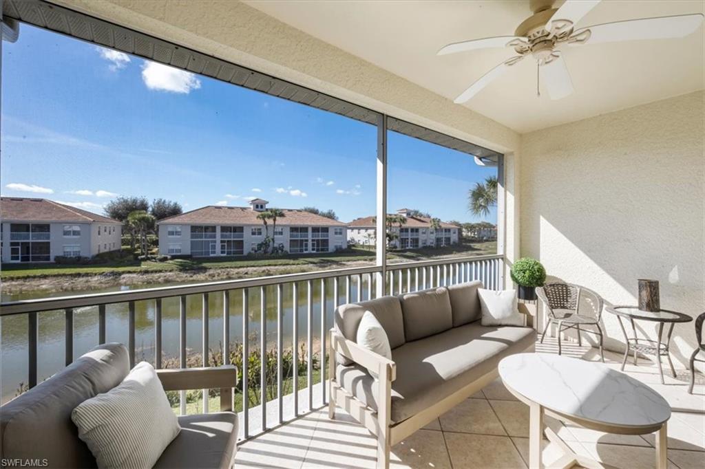 Sunroom / solarium featuring a water view, ceiling fan, an outdoor hangout area, a textured wall, and a balcony