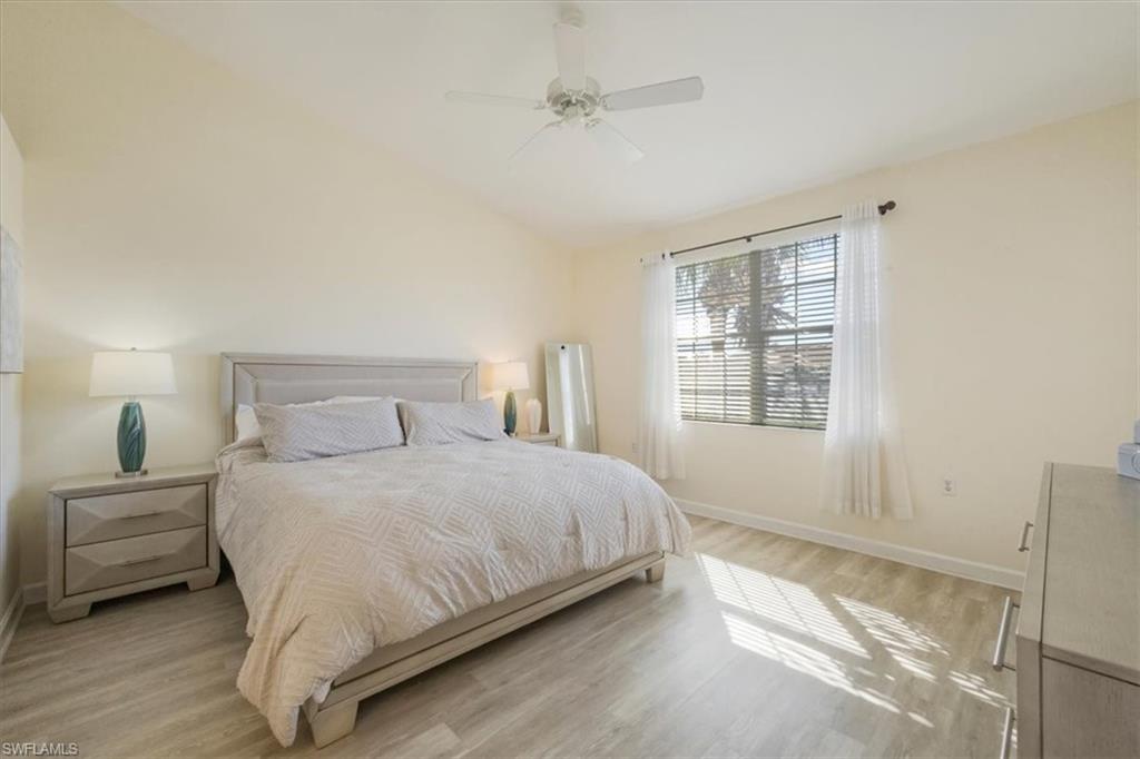 Bedroom with vaulted ceiling, light wood-type flooring, and a ceiling fan