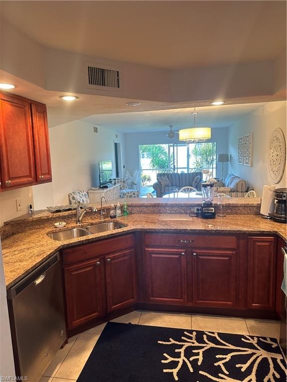 Kitchen with light tile patterned flooring, dishwashing machine, stone countertops, and sink