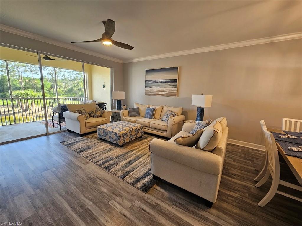 Living room with crown molding, ceiling fan, wood finished floors, and baseboards