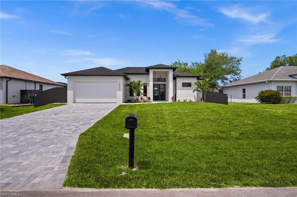 Contemporary single-story residence featuring a dark shingle roof, white exterior, and a two-car garage