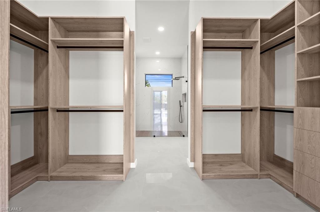 Custom closet system featuring light wood-finish cabinetry, integrated shelving, and hanging rods